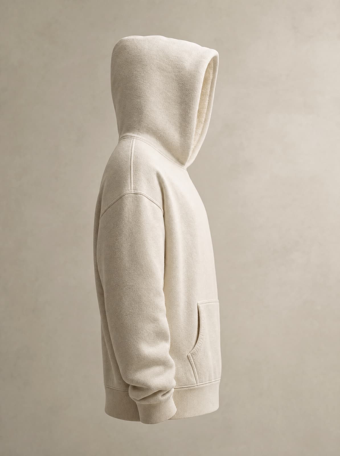 Hoodie heavyweight crème — profil, capuche relevée, texture du molleton lisible