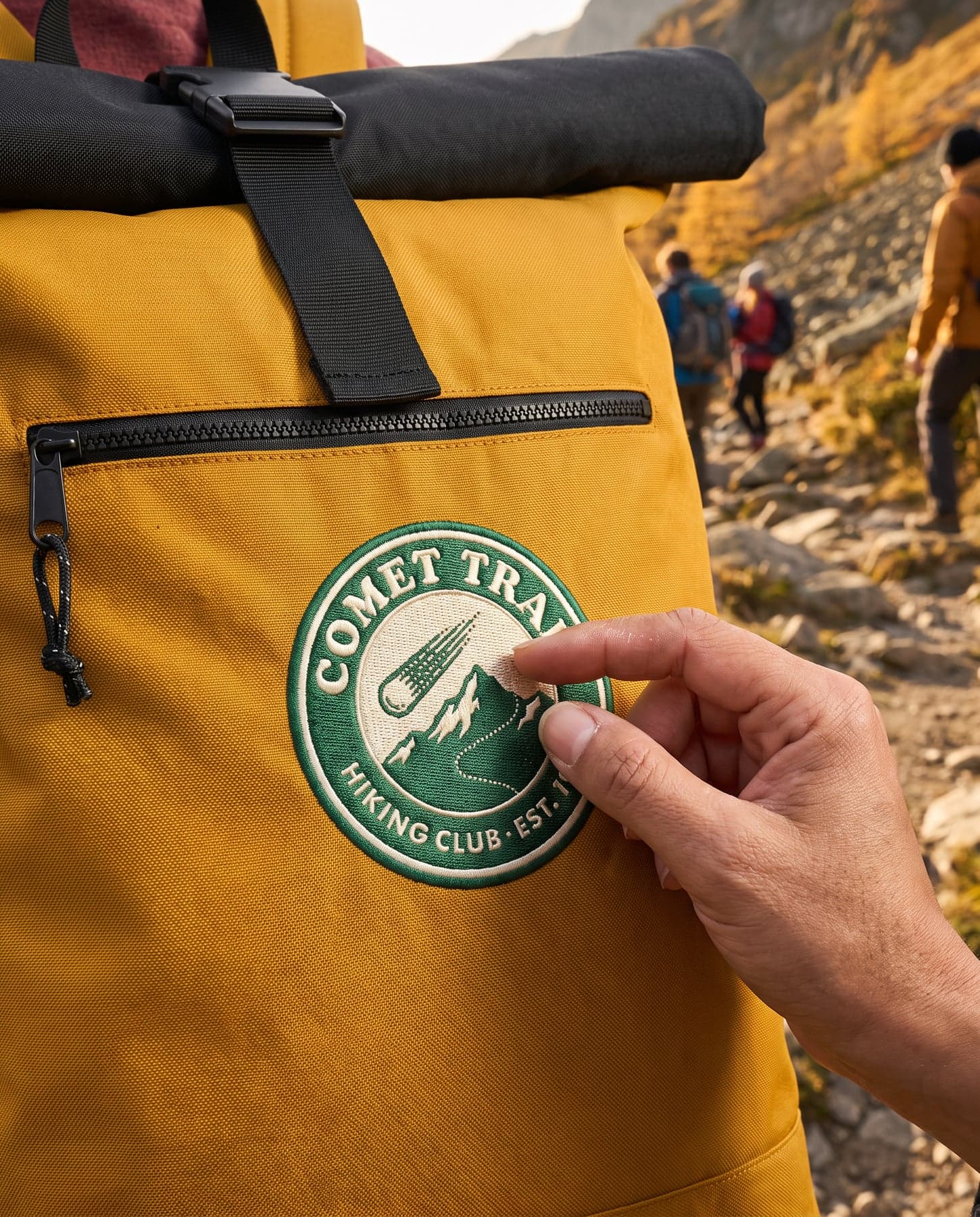 Le marquage — BagBase Recycled Roll-Top Backpack Mustard, broderie sur la poitrine, devant